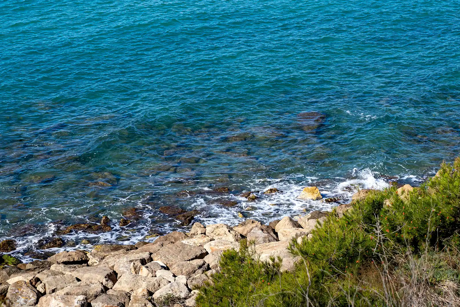 Agua turquesa entre las rocas de la costa del Garraf